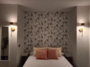 a bedroom with a bed with a floral wallpaper at Abril 56 Villa&Suites in Oreña