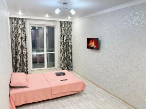 阿斯塔纳ЖК Рио де Жанейро的房间里有一张床，墙上还有一个火炉。