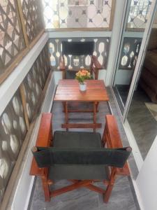 un tavolo di legno con una sedia, un tavolo e una panca di PR Home Mtwapa Pride Apartments a Mombasa
