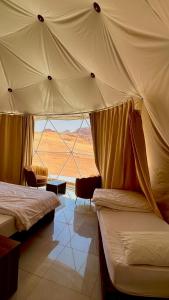 a bedroom with two beds and a view of the desert at Wadirum Leen camp in Wadi Rum