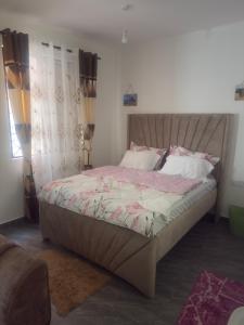 una camera da letto con un letto grande con lenzuola rosa di PR Home Mtwapa Pride Apartments a Mombasa