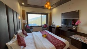 um quarto de hotel com uma cama grande e uma janela grande em The Zen Villa em Dalhousie