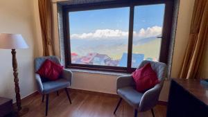 um quarto com duas cadeiras e uma grande janela em The Zen Villa em Dalhousie