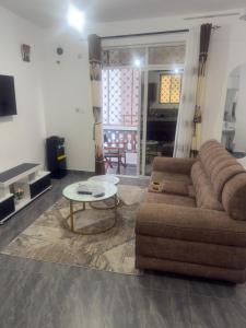 un soggiorno con un divano e un tavolo di PR Home Mtwapa Pride Apartments a Mombasa