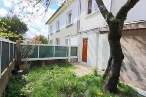 a white house with a red door and a tree at Coin de paradis à Grenoble in Poisat
