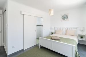a white bedroom with a bed and a closet at Spacious house in Olhao in Quelfes
