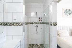 a white bathroom with a shower and a bed at Spacious house in Olhao in Quelfes