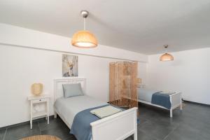 a bedroom with two beds and two tables and two lamps at Spacious house in Olhao in Quelfes +36 photos