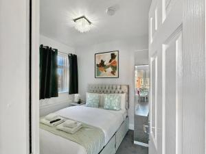 una camera da letto bianca con un letto e una finestra di Granada Apartments Holmfield Rd a Blackpool