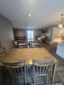 una sala da pranzo con un grande tavolo in legno e sedie di Bizlodge County Greenside Lakeview a Deseronto