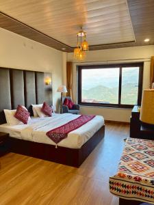 um quarto com uma cama grande e uma janela grande em The Zen Villa em Dalhousie