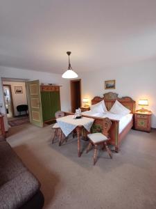 una camera da letto con un letto, un tavolo e delle sedie di Villa Egger a Lofer