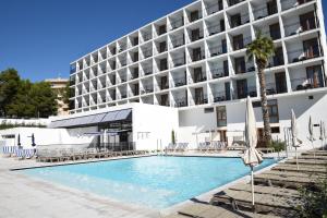 um hotel com piscina em frente a um prédio em Hotel SunClub CalaVinya - Adults Recommended em Salou