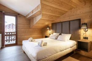 ein Schlafzimmer mit einem großen weißen Bett und einer Holzwand in der Unterkunft Résidence Les Balcons de Belle Plagne in Belle Plagne + 56 Fotos
