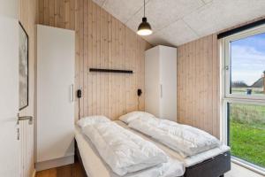 Un dormitorio con dos camas y una ventana. en Spacious Holiday Home On Als Near Little Belt, en Asserballeskov