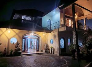 une grande maison avec une entrée la nuit dans l'établissement Village by the river, à Gianyar