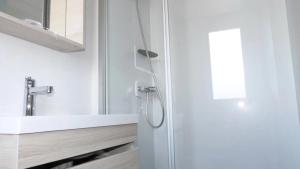 a bathroom with a shower with a sink and a mirror at ZEcamping 3 à 150m de la plage cadre unique de la presquîle de Giens in Hyères +41 photos