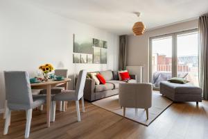 a living room with a couch and a table and chairs at Żurawie 231 in Gdańsk