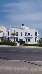 a large white building on the side of a street at Cali Residence in Sharm El Sheikh