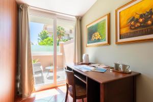 アマンテーアにあるDimore Morelli Amanteaのデスク、テーブル、窓が備わる客室です。