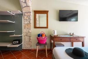 アマンテーアにあるDimore Morelli Amanteaのベッドと机があり、椅子の上にバスケットが置かれた寝室