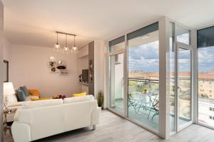 a living room with a white couch and a balcony at Elegant Urban Retreat - City Center in Arad