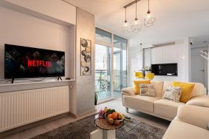 a living room with a couch and a tv at Elegant Urban Retreat - City Center in Arad