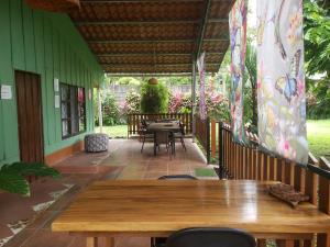 a patio with a wooden table and chairs at Arenal Hostel La Catarata in Fortuna