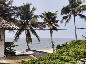 a view of the ocean from a beach with palm trees at Cuba beach villa in Alleppey