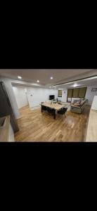 Una gran sala de estar con una mesa y un sofá. en Cozy Central Apartment 2, en Sighetu Marmaţiei