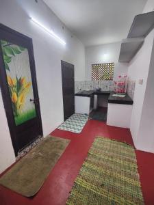 a room with a kitchen with a red floor at Cuba beach villa in Alleppey