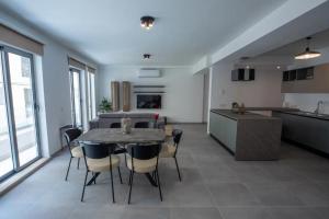 Una cocina y un comedor con mesa y sillas. en Elegant 2BR Seaside Stay, Balluta Bay Oasis P2, en Sliema