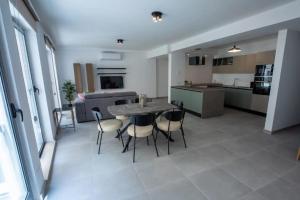 a kitchen and dining room with a table and chairs at Elegant 2BR Seaside Stay, Balluta Bay Oasis P2 in Sliema +19 photos