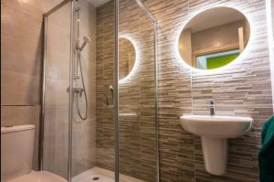 Un baño con lavabo y ducha con espejo. en Elegant 2BR Seaside Stay, Balluta Bay Oasis P2, en Sliema
