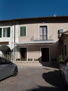 a white house with a car parked in front of it at VILLA ISABELLA Ospedale Cisanello in Pisa