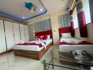 a bedroom with two beds and a star on the ceiling at Hotel Relax Residency in Mumbai +6 photos