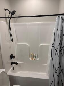a bathroom with a white tub and a shower at Custom Luxury Rambler in Highland Hills in Rochester +34 photos