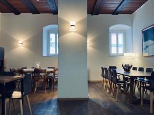 a dining room with tables and chairs and lights at Sust Lodge in Hospental +19 photos