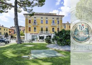 Palazzo Visconti Luxury Suite DesenzanoLoft Official Partner Homes & Villas by Marriott Bonvoy في ديسينسانو ديل غاردا: مبنى أصفر كبير مع علامة أمامه