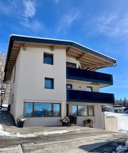 a white building with blue balconies on it at Vista Apartments in Seefeld in Tirol