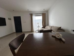 un soggiorno con un tavolo e un divano di Central Muscat 1BR Petit Villa a Mascate