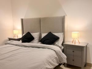 una camera da letto con un letto grande con due comodini di Central Muscat 1BR Petit Villa a Mascate