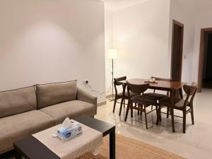 un soggiorno con un divano e un tavolo di Central Muscat 1BR Petit Villa a Mascate