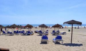 eine Gruppe von Stühlen und Sonnenschirmen an einem Strand in der Unterkunft Hospederia IMAR by Cadiz4Rentals in Cádiz