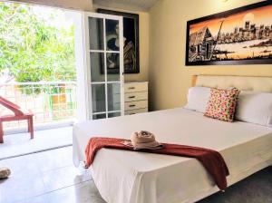 a bedroom with a bed and a large window at Casa Del Pintor in Santa Marta