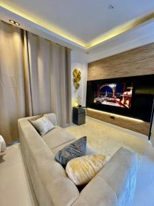 un soggiorno con divano e TV a schermo piatto di IVORY Home stay a Dar es Salaam