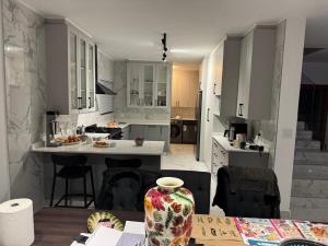 Una cocina con gabinetes blancos y un jarrón sobre una mesa. en 49 The Hill, en Plettenberg Bay