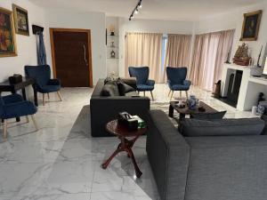 Una sala de estar con sofás y sillas y una chimenea. en 49 The Hill, en Plettenberg Bay 3 fotos más