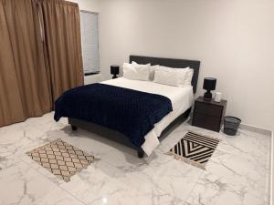 Un dormitorio con una cama grande y suelo de mármol. en 49 The Hill, en Plettenberg Bay