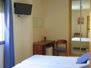 sypialnia z 2 łóżkami, biurkiem i lustrem w obiekcie Pensión La Venta w mieście Puerto de Mazarrón +34 zdjęcia